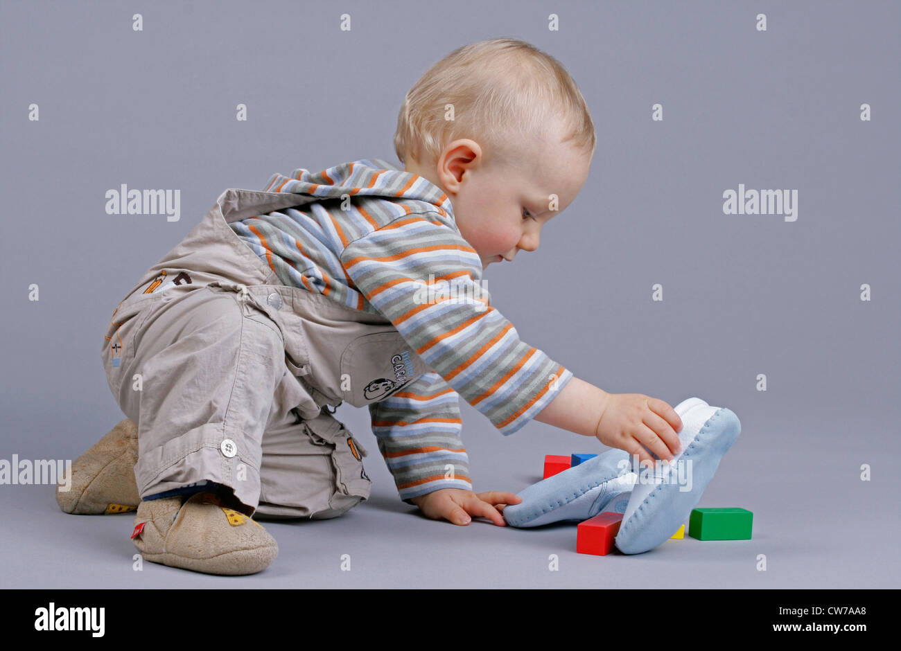 little boy playing with shoes and bricks, Germany Stock Photo