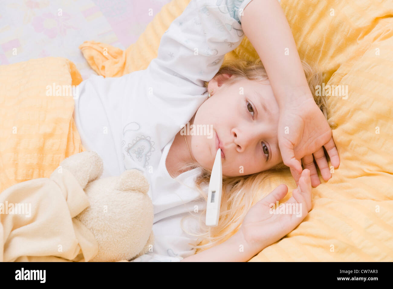 sick girl with clinical thermometer in bed Stock Photo