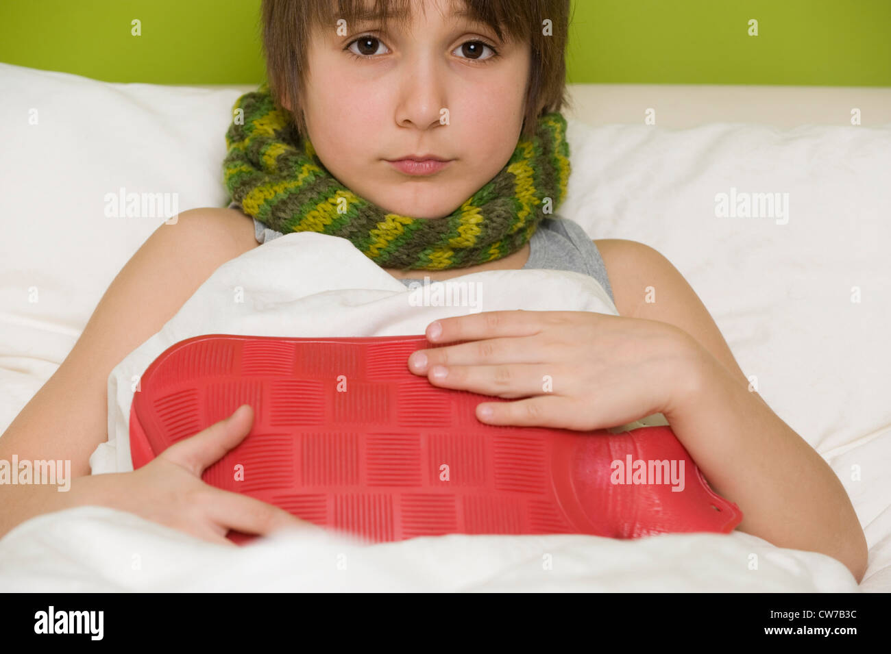 sick boy with hotwater bottle in bed Stock Photo Alamy