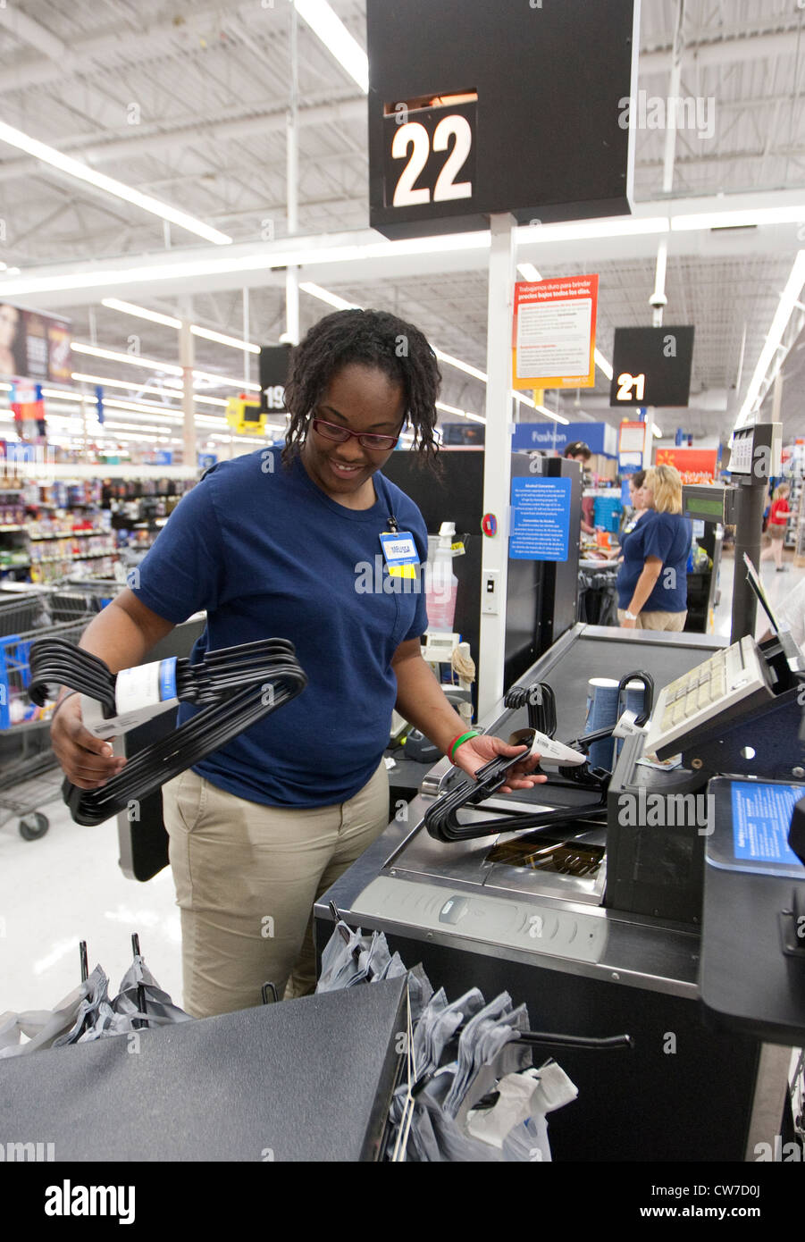 Smiling African-American female cashier rings up products for customer at a Wal-Mart Supercenter in San Marcos, Texas Stock Photo