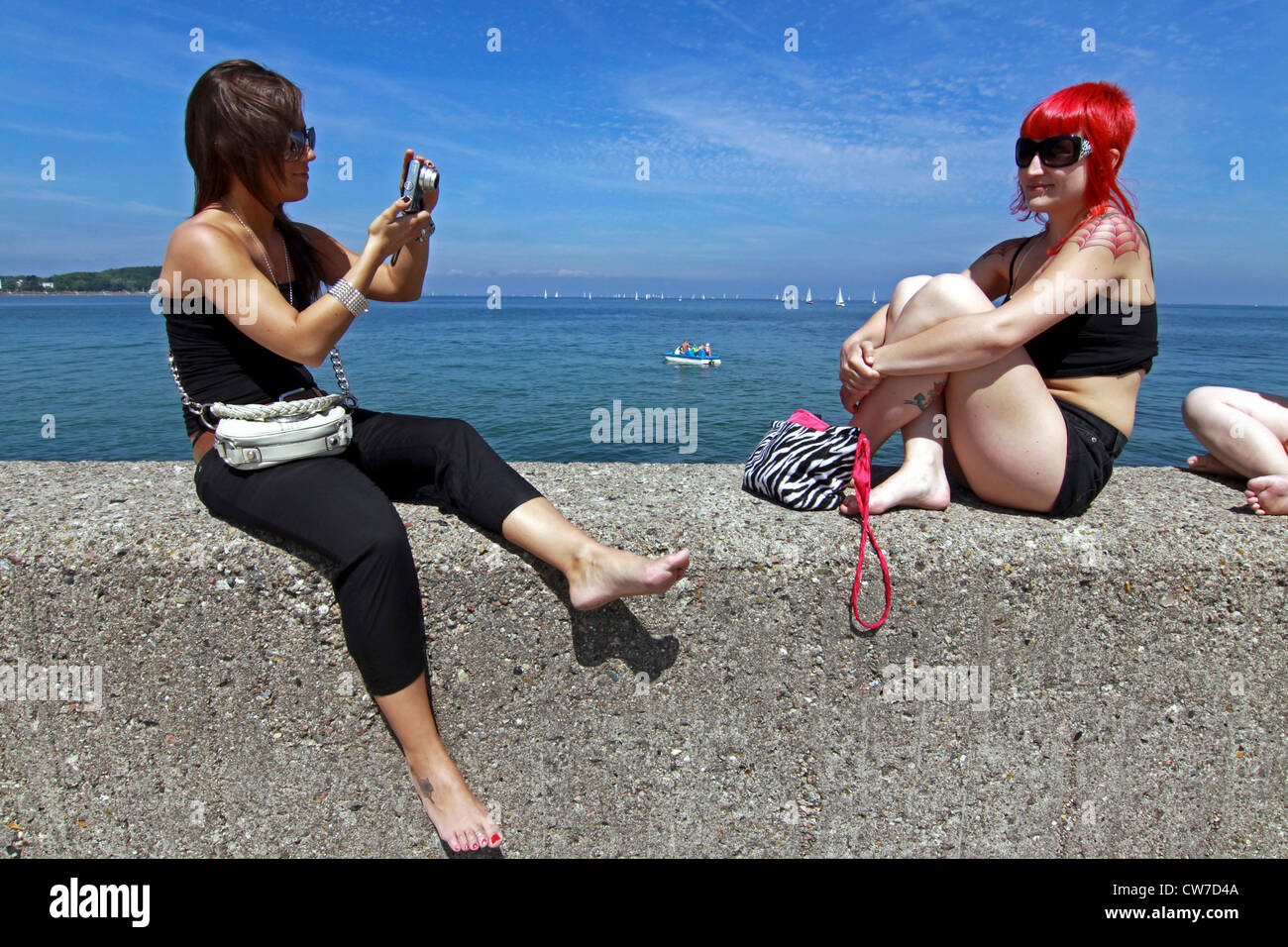 Woman sitting on a wall hi-res stock photography and images - Alamy