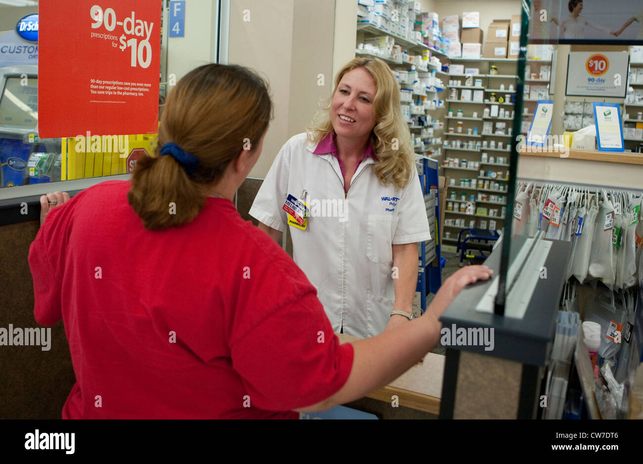 Female white Pharmacist gives medical advice to female customer at Wal-Mart Supercenter Pharmacy in San Marcos, Texas Stock Photo