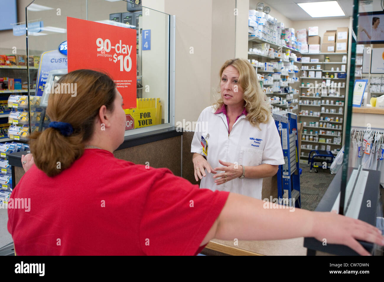 Female white Pharmacist gives medical advice to female customer at Wal-Mart Supercenter Pharmacy in San Marcos, Texas Stock Photo