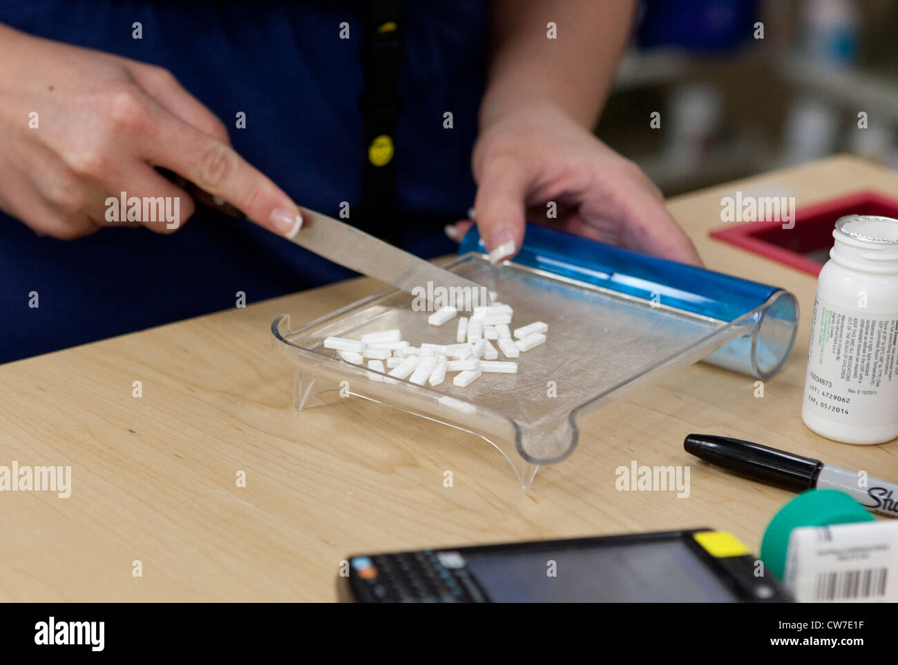 Female employee counts pills, fills medicine prescriptions at Wal-Mart Supercenter pharmacy in San Marcos, Texas Stock Photo