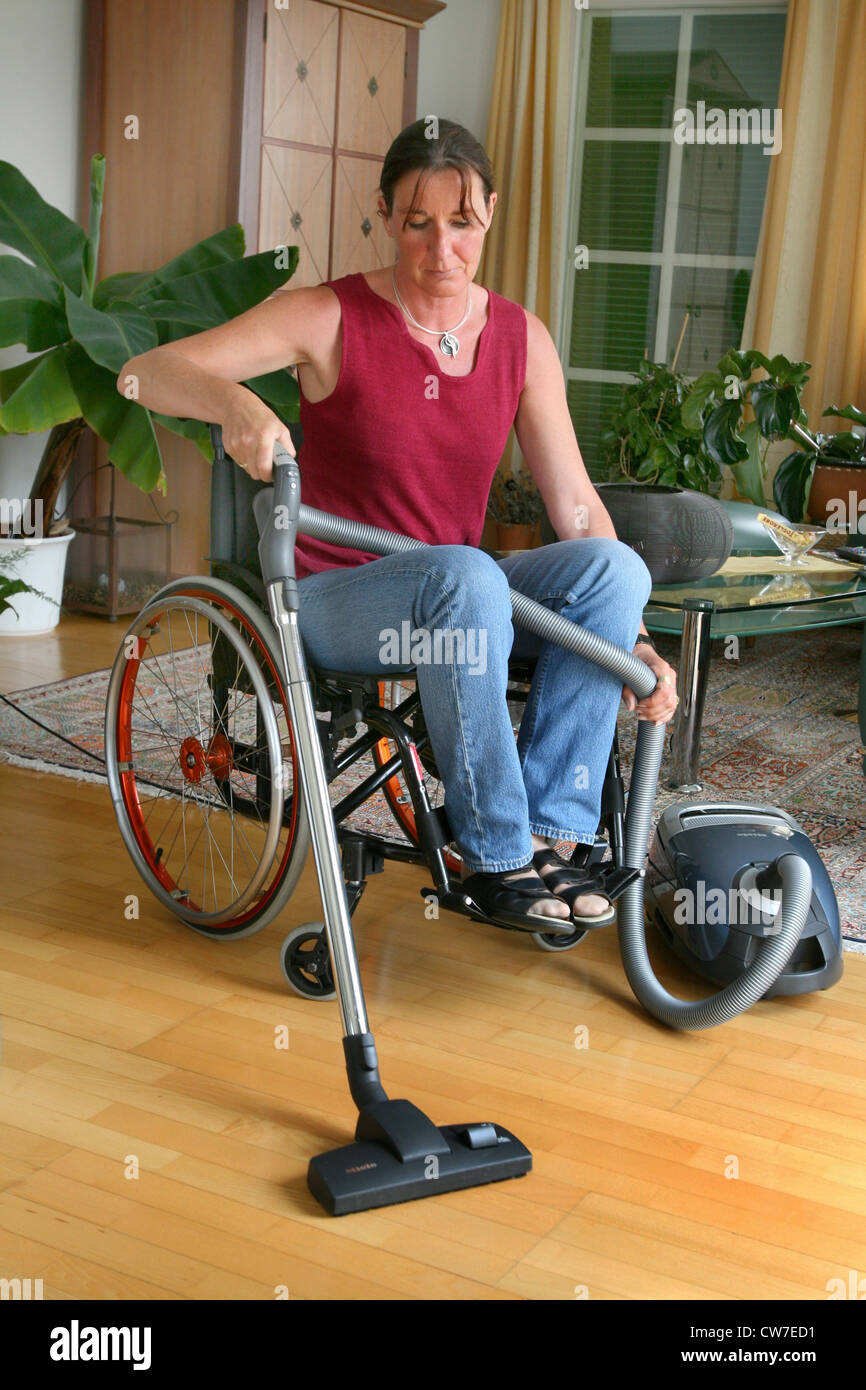 woman in a wheelchair using vacuum cleaner Stock Photo Alamy