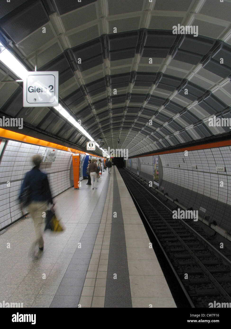 Long tube with tracks of a subway station - person walks over side walk, Germany, Hamburg Stock Photo