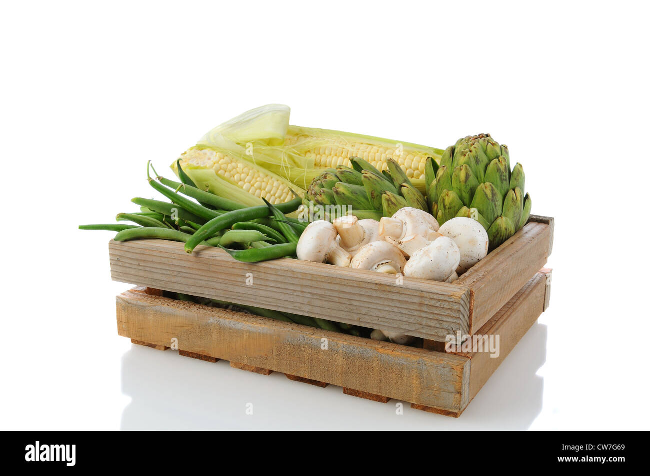 Wooden Produce crate with assorted vegetables, over a white background with reflection. Stock Photo