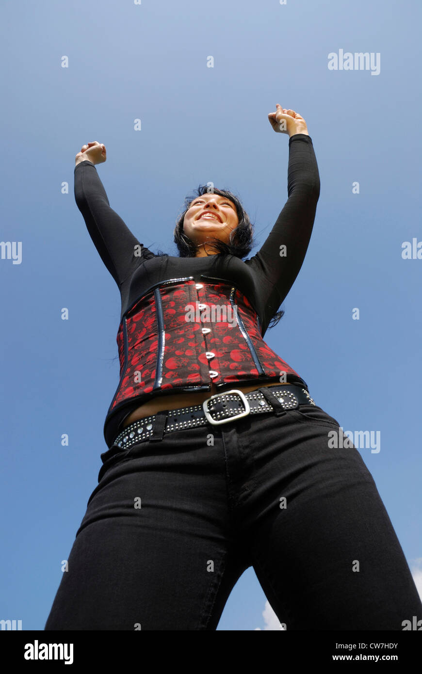 woman in corset, stretching out her arms into the air Stock Photo