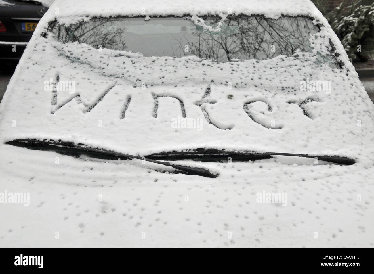 parking car in winter, somebody has written 'winter' on the snowcovered windscreen, Germany Stock Photo