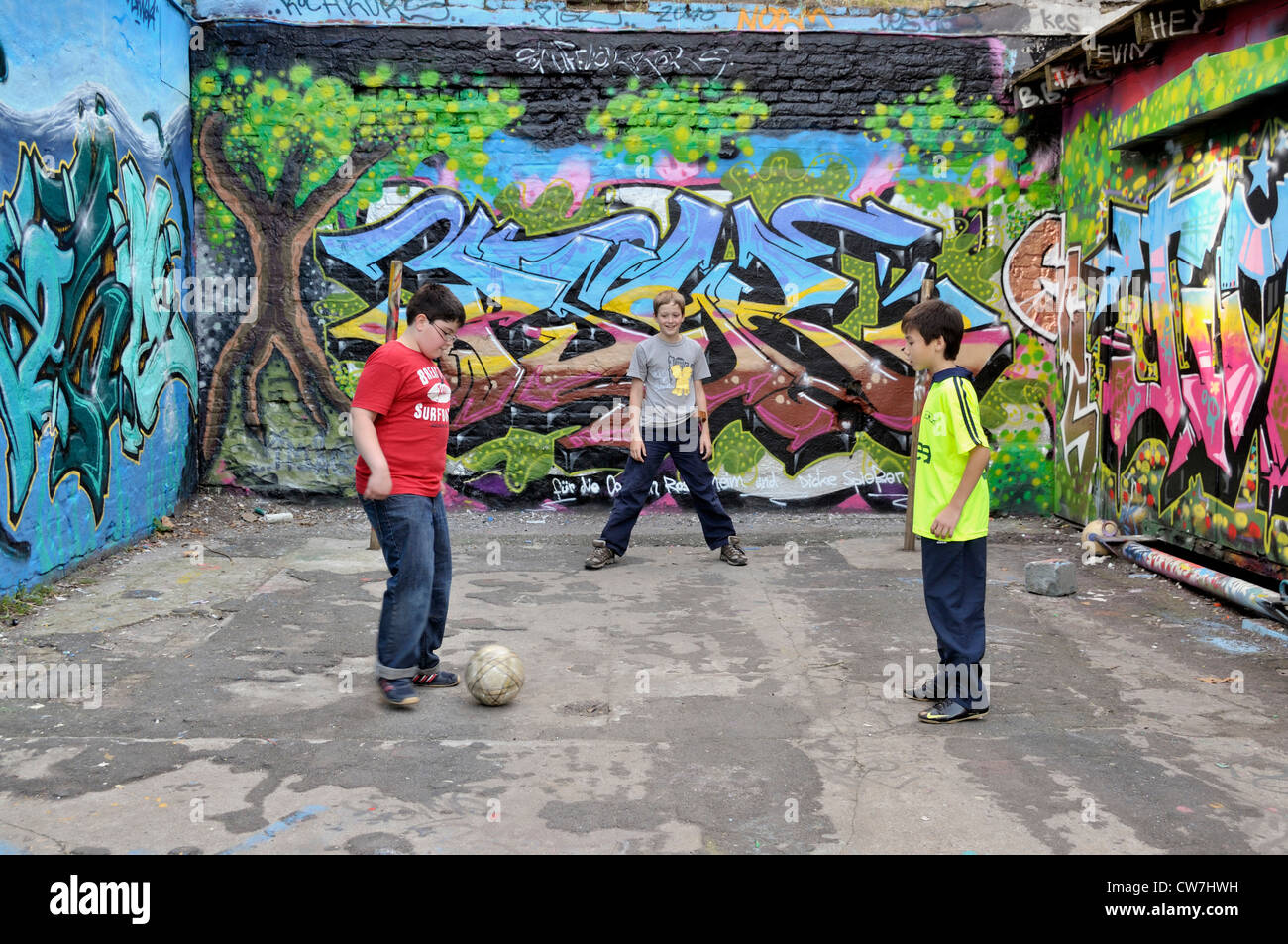 Serbian, German and Thai boys playing together soccer in the street, Germany, North Rhine-Westphalia, Cologne Stock Photo