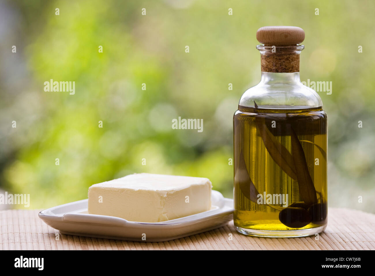 piece of butter with bottle of olive oil on a desk Stock Photo - Alamy