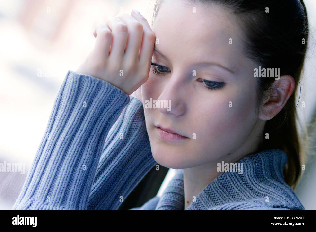 young absent-minded woman at a window Stock Photo