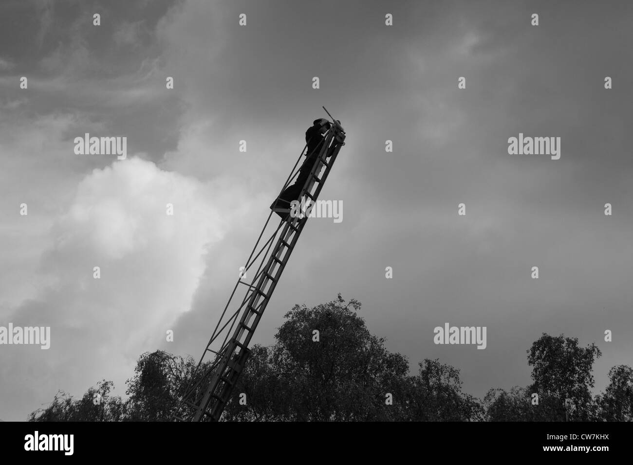 Member of the 1940's National Fire Service on ladder with water jet/hose Stock Photo