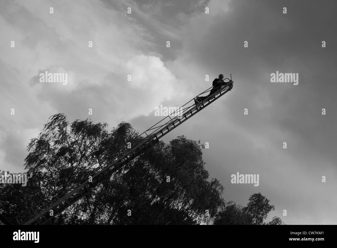 Member of the 1940's National Fire Service on ladder with water jet/hose Stock Photo