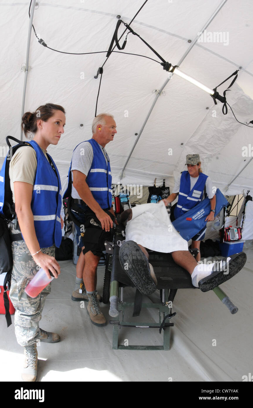 Medical providers from the 102nd Medical Group, evaluate a patient's condition during the Homeland Response Force (HRF) training exercise at Camp Edwards, Mass. Aug. 8. The exercise, hosted by the Massachusetts National Guard,trains Soldiers and Airmen assigned to the FEMA Region 1 HRF team to respond to a large scale CBRN incident in an effort to safeguard lives throughout New England. Stock Photo