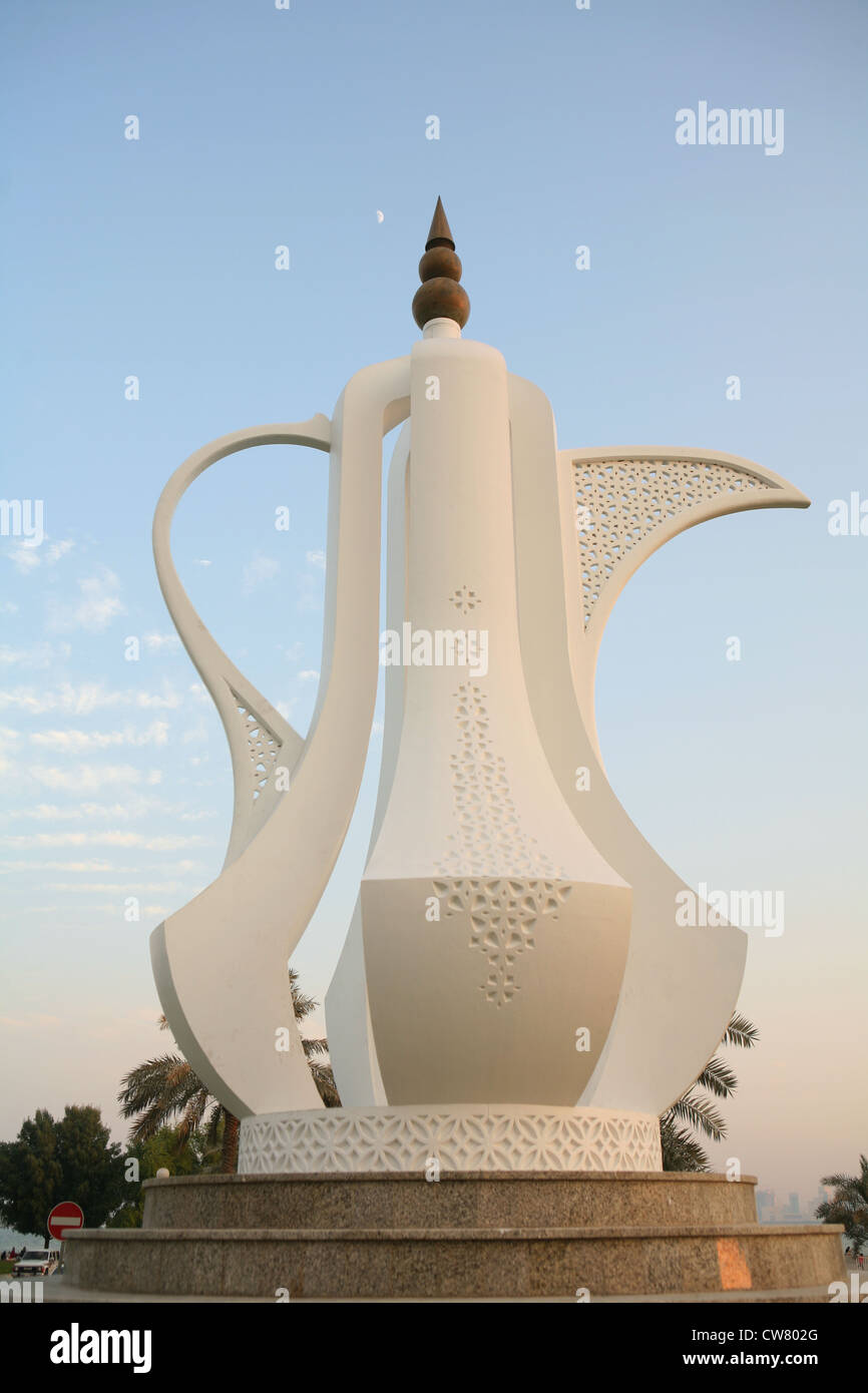 The Dallah (coffeepot) monument on the Corniche in Doha, Qatar, at sunset, with the moon hanging high in the sky above. Stock Photo
