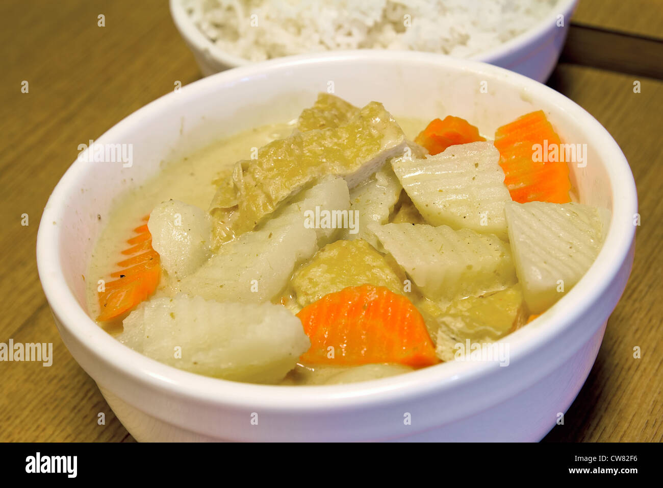 Thai Yellow Curry with Tofu Potatoes Carrots with Bowl of Rice Closeup