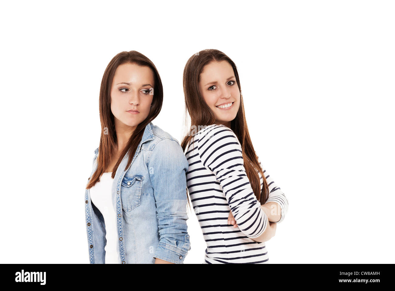 one happy and one upset teenager standig back to back on white background Stock Photo