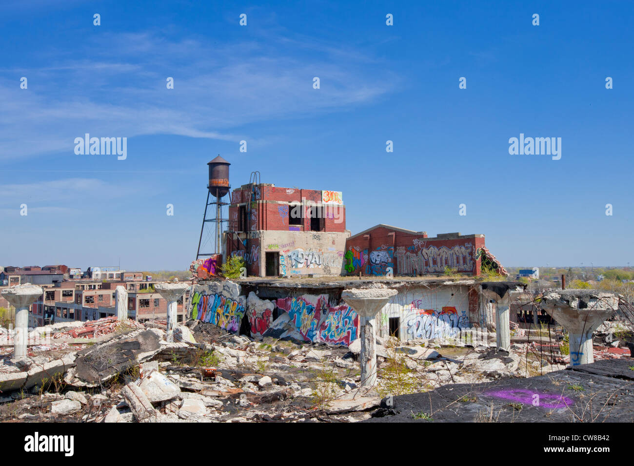 Roof top of an abandoned car manufacturing plant in Detroit Michigan. The ceiling supports have toppled over graffiti on walls Stock Photo