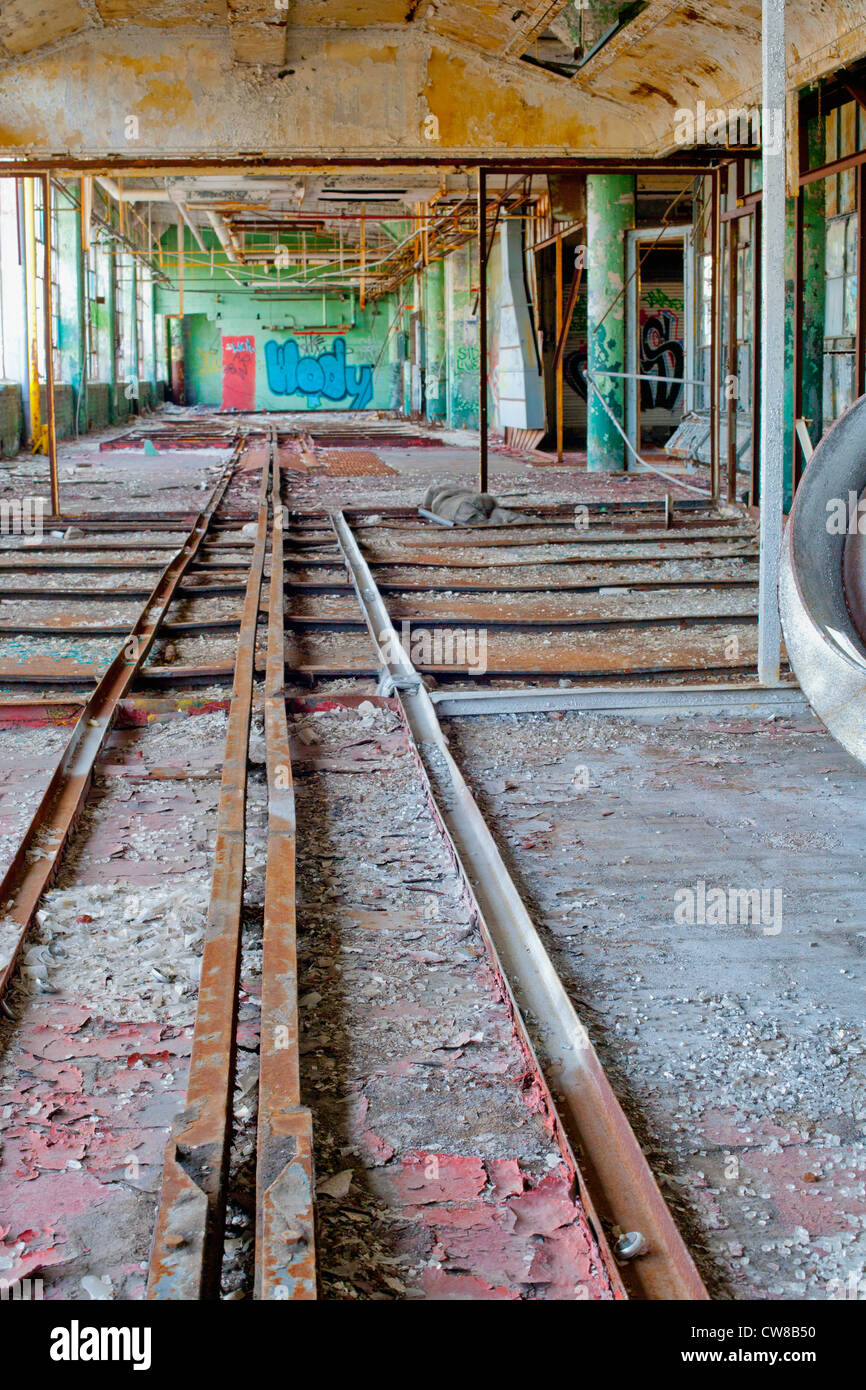 Interior of an abandoned car factory in Detroit Michigan.These are the old tracks for the assembly line. Stock Photo