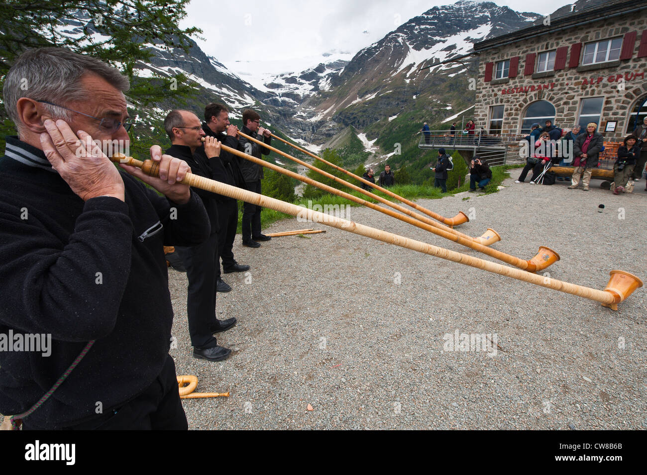 Men playing alpenhorn or alpine horn, Switzerland. Stock Photo