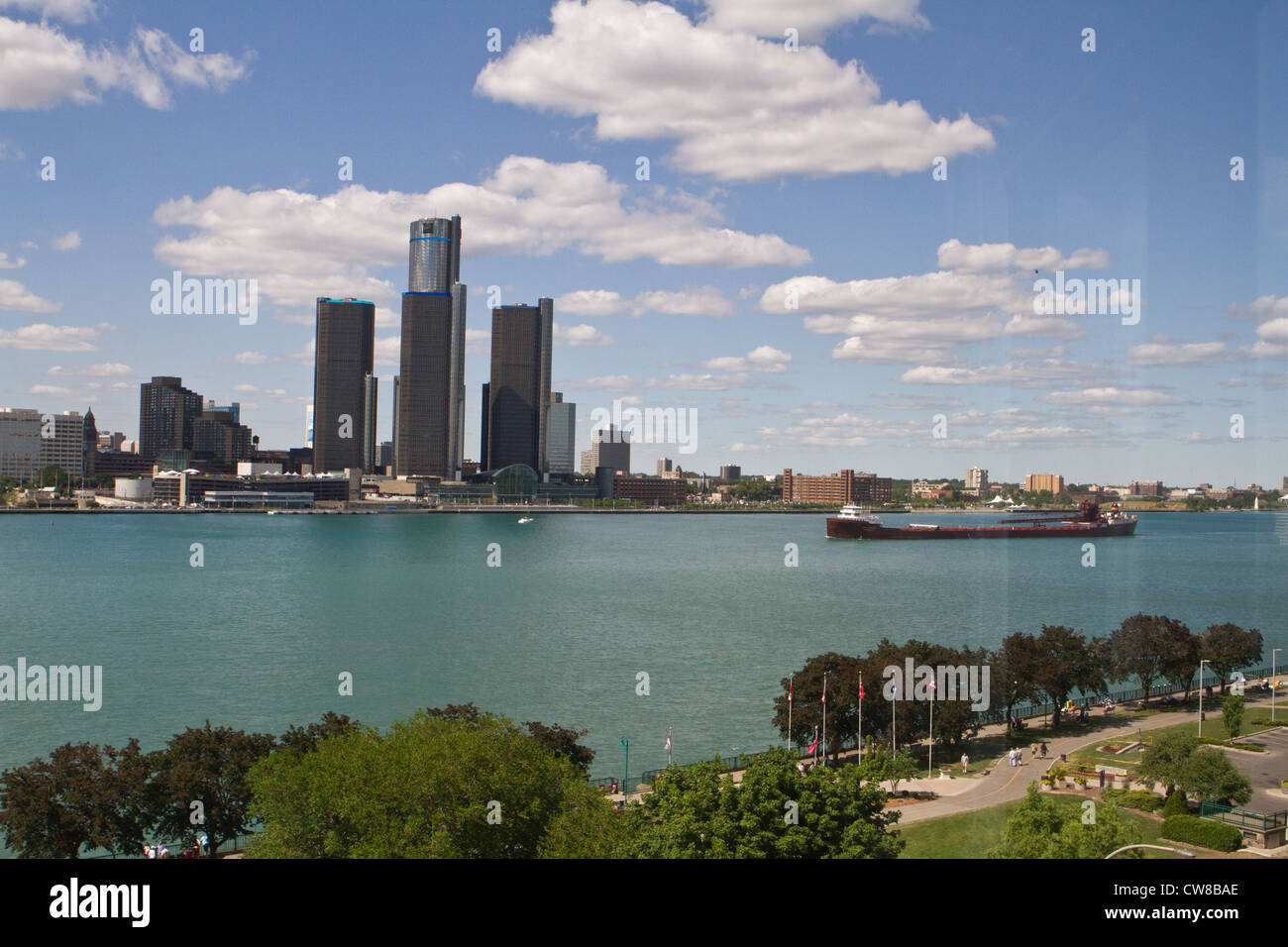 Detroit Michigan USA as seen from Windsor Ontario across the Detroit River. There is a freighter heading downstream. Stock Photo