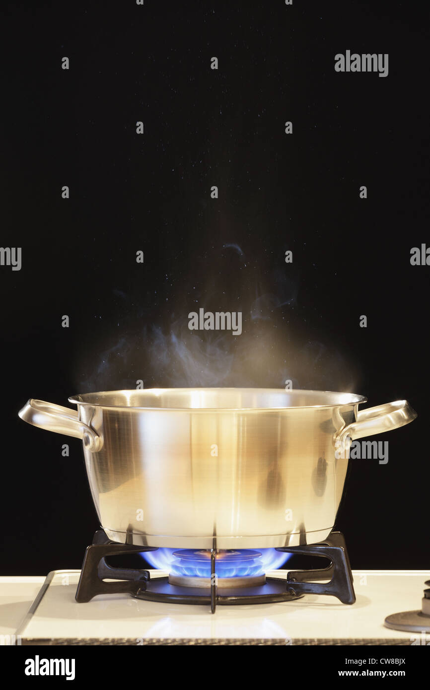Lit Gas Stove With Pot Stock Photo
