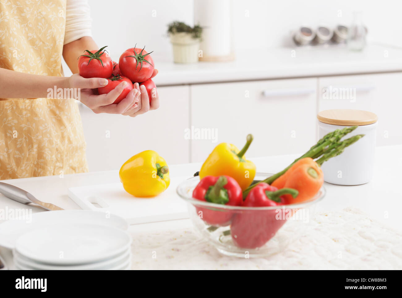 Woman Holding Fresh Tomatoes In Kitchen Stock Photo