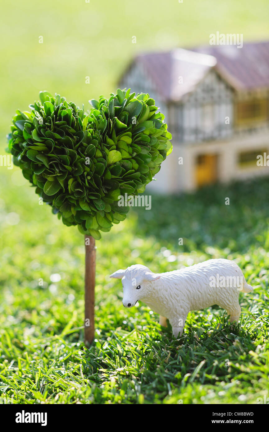 White Sheep Model On Grassy Field Stock Photo