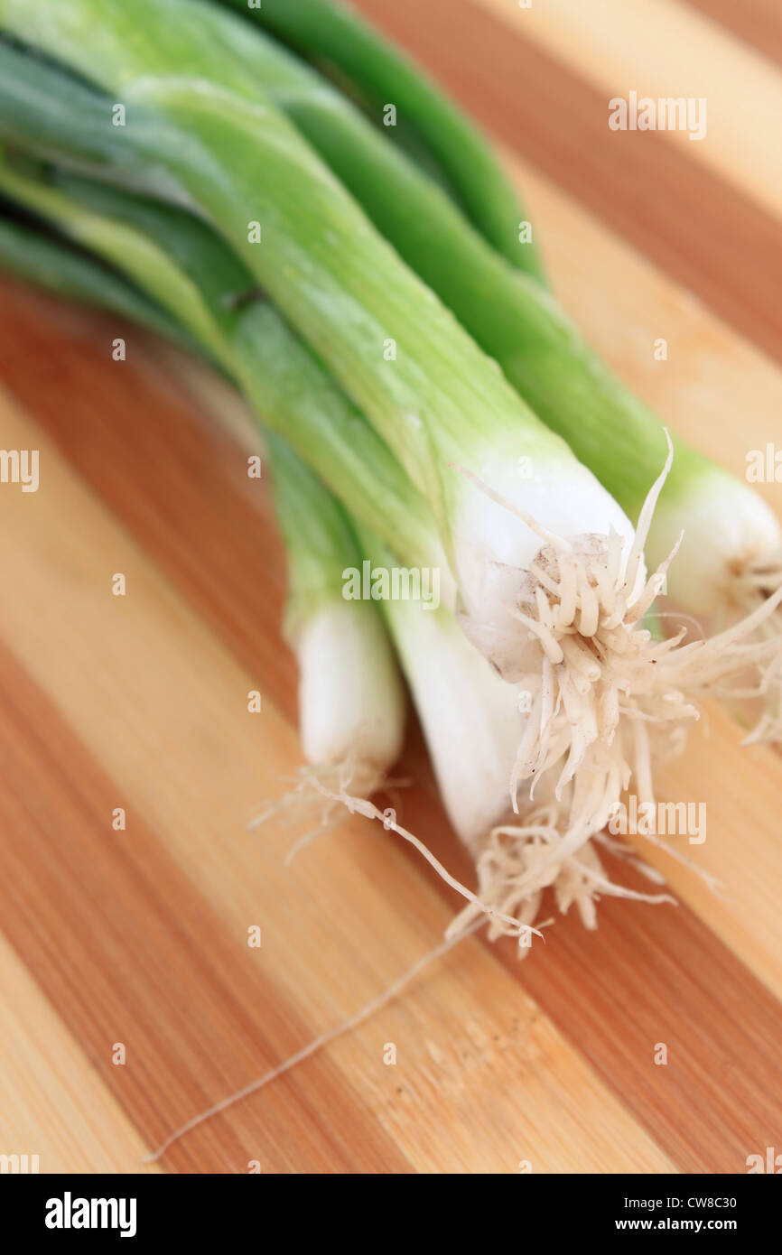 Green onions or scallions on wooden cutting board Stock Photo Alamy