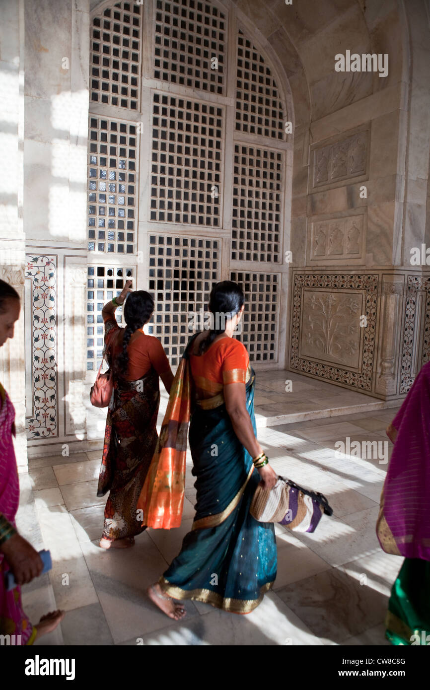 Indian women in saris walking through the interior of the Taj Mahal Stock Photo