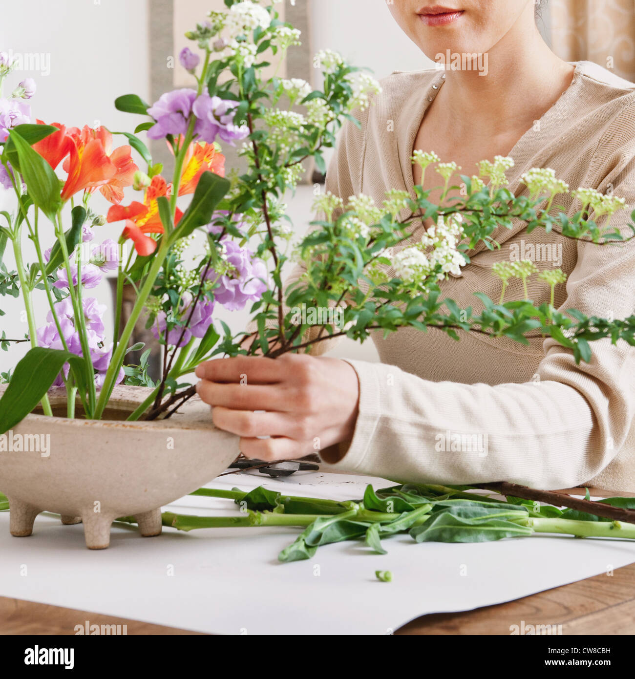 Woman Arranging Flowers In Pot Stock Photo