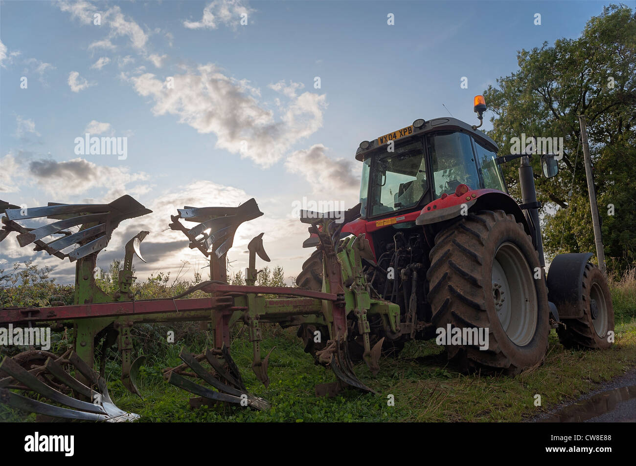 massey ferguson tractor with plough at sunset Stock Photo