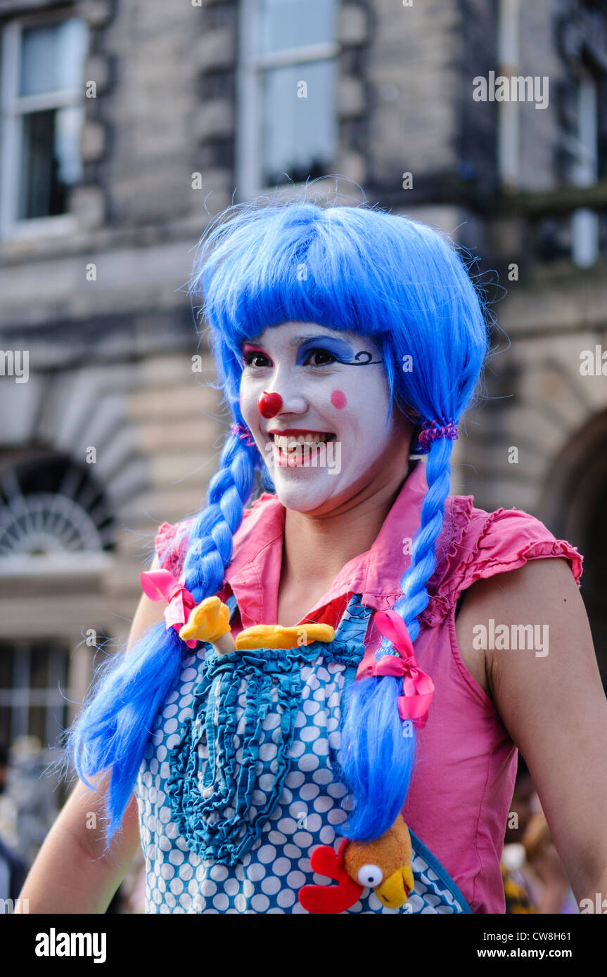 Young woman dressed as a colourful happy clown Stock Photo