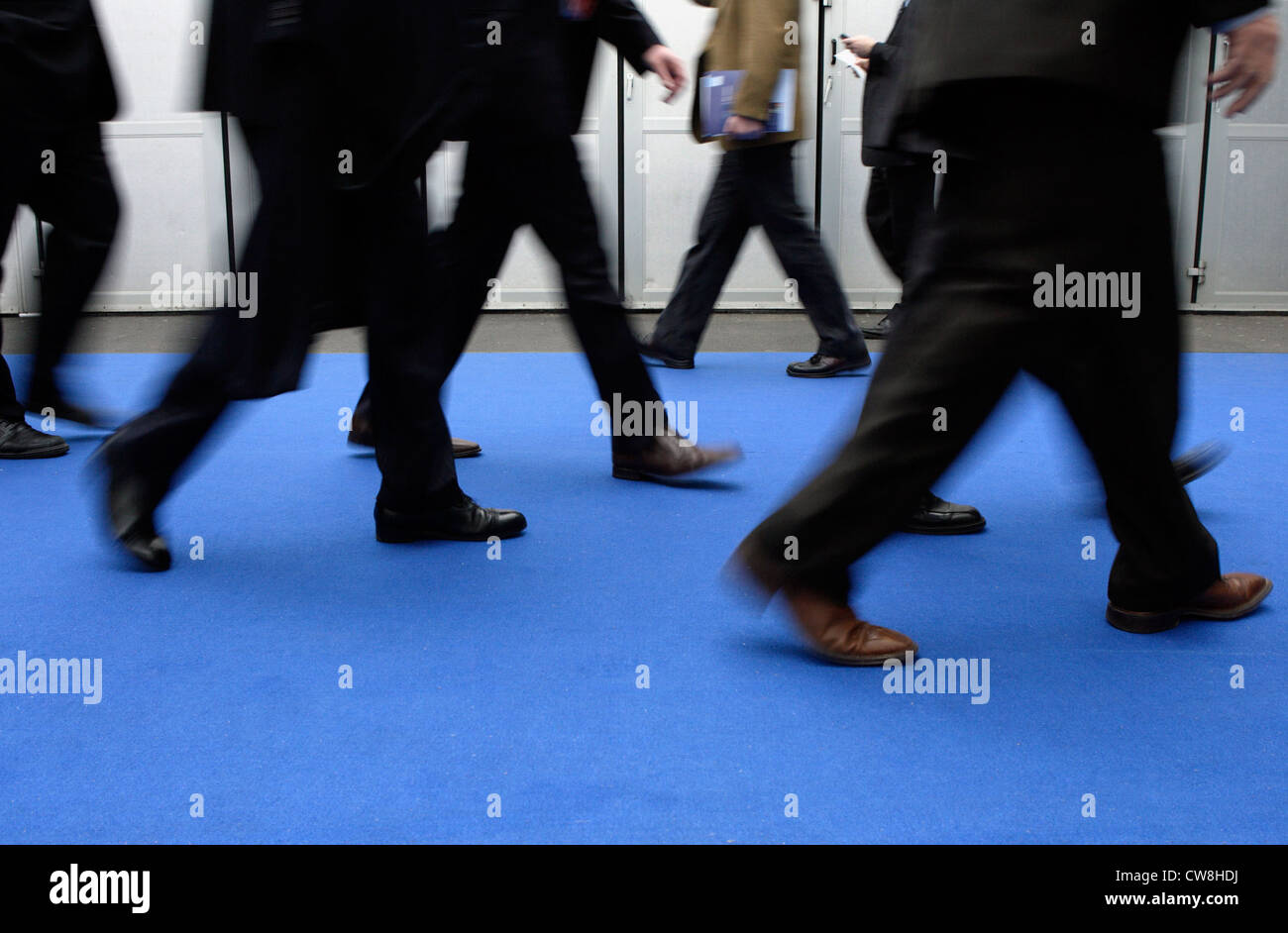 Business people walking over a blue carpet Stock Photo