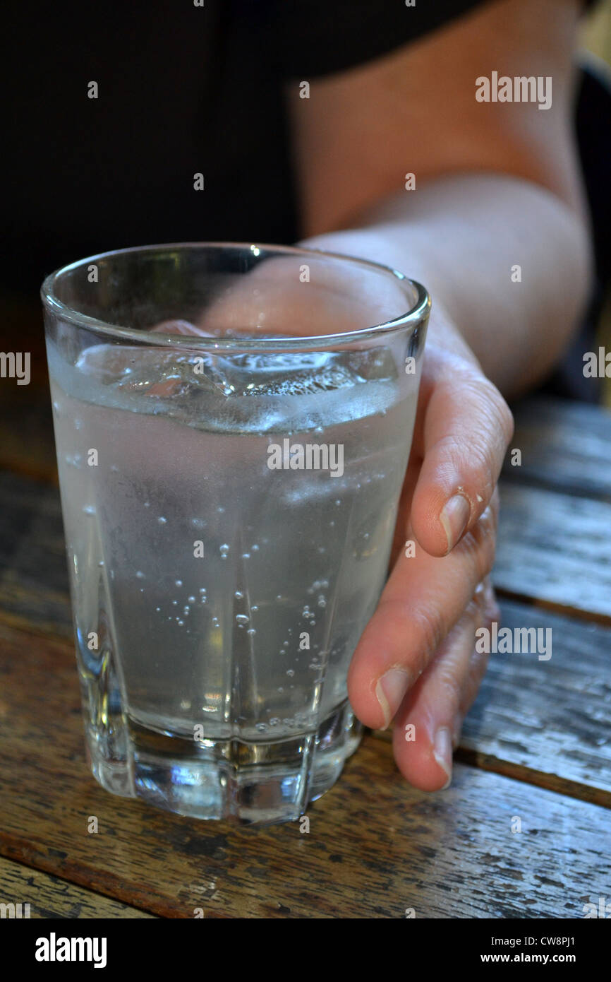 lady holding a glass of water with icecubes Stock Photo