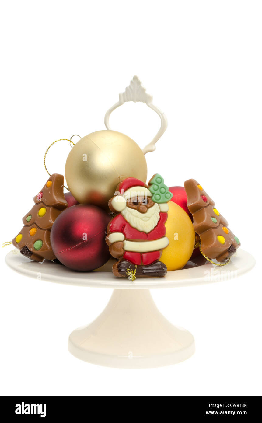 Belgian chocolate Christmas trees and a chocolate Father Christmas on a cake plate - studio shot with a white background Stock Photo