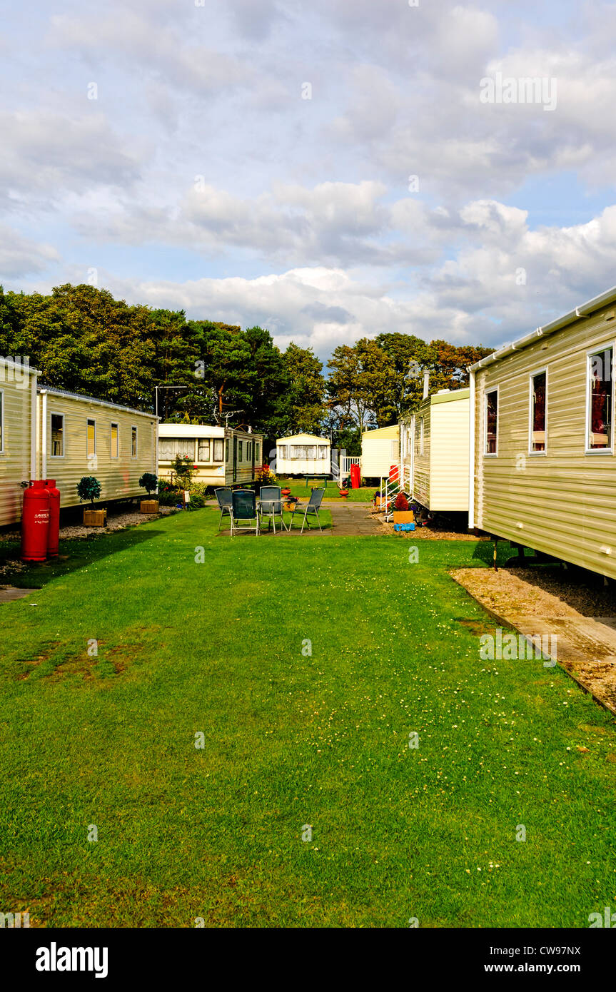 Modern static caravans set on secluded gravel sites adjacent to mown