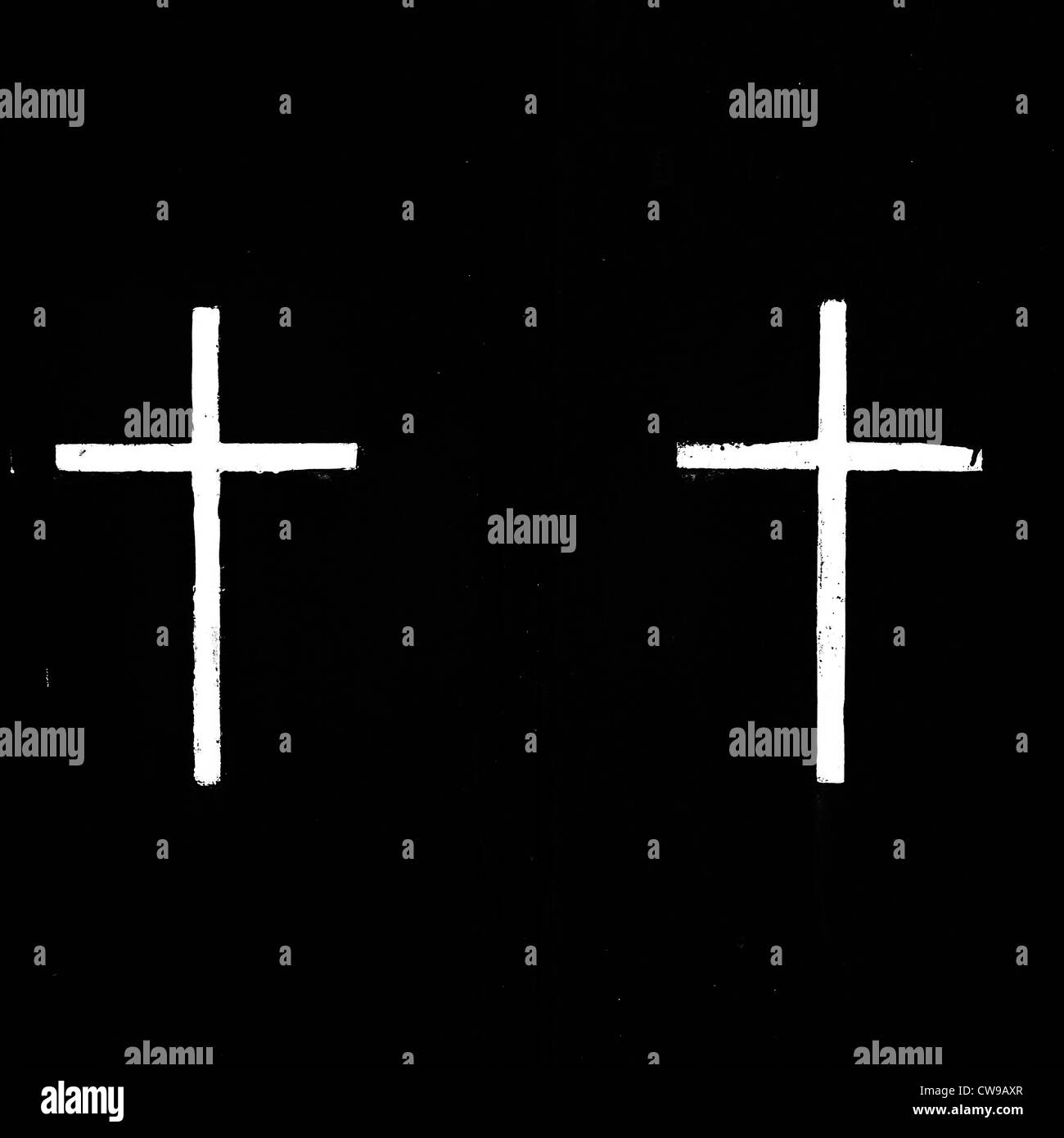 two white, painted crosses on a black background Stock Photo