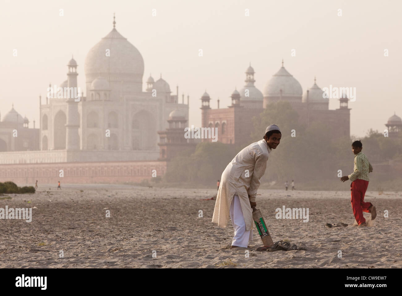 Boys playing cricket on the banks of the Yamuna river, with the Taj Mahal in the background Stock Photo