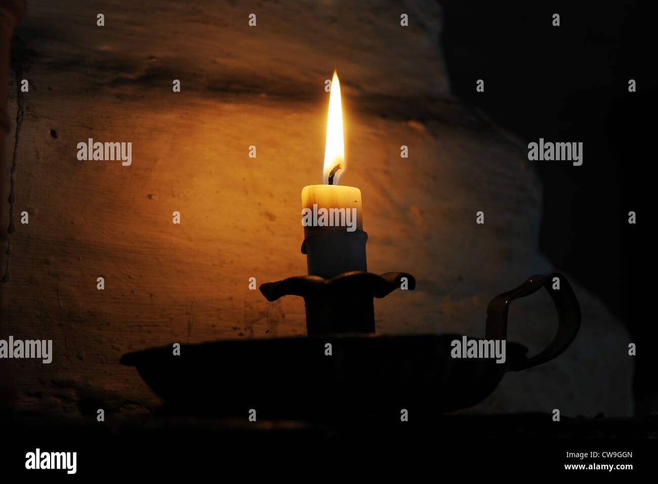 Candle burning in old fashioned candle holder Uk Stock Photo Alamy