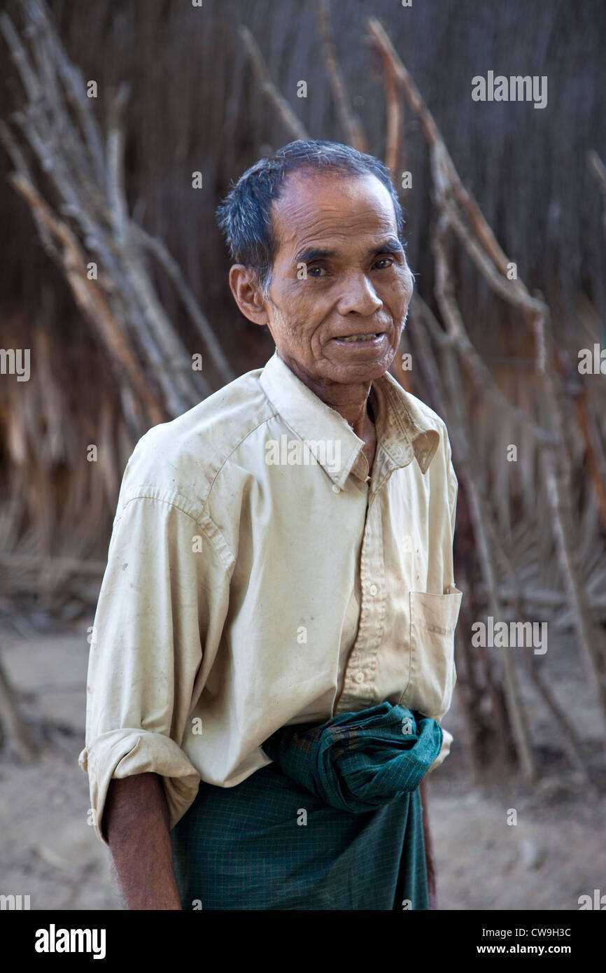 Myanmar, Burma. Middle-aged Burmese Man in Village near Bagan. His longyi is tied in a knot in front. Stock Photo