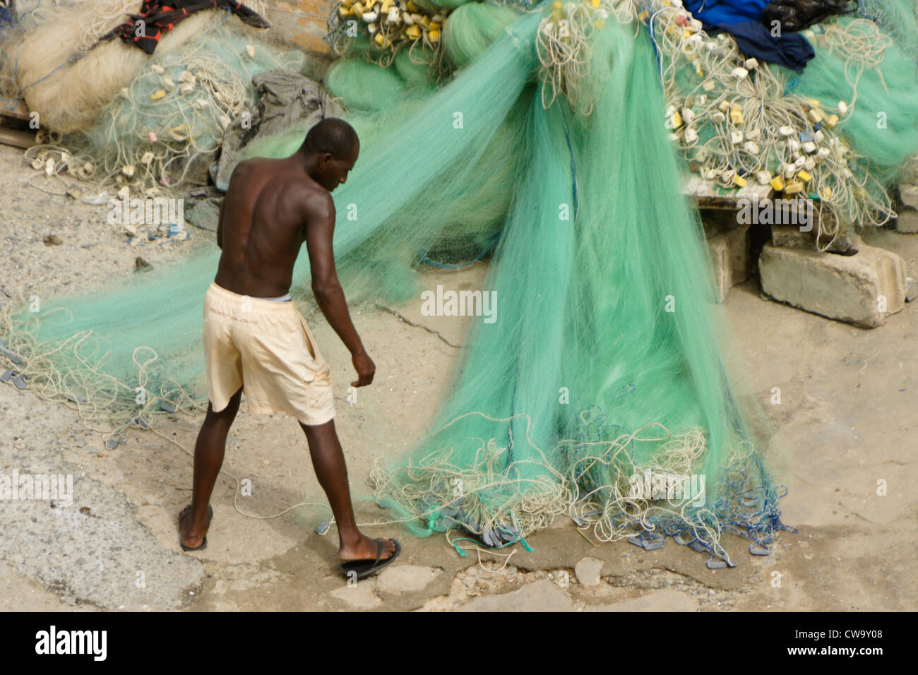 Fisherman cleaning and untangling nets, Cape Coast, Ghana Stock Photo