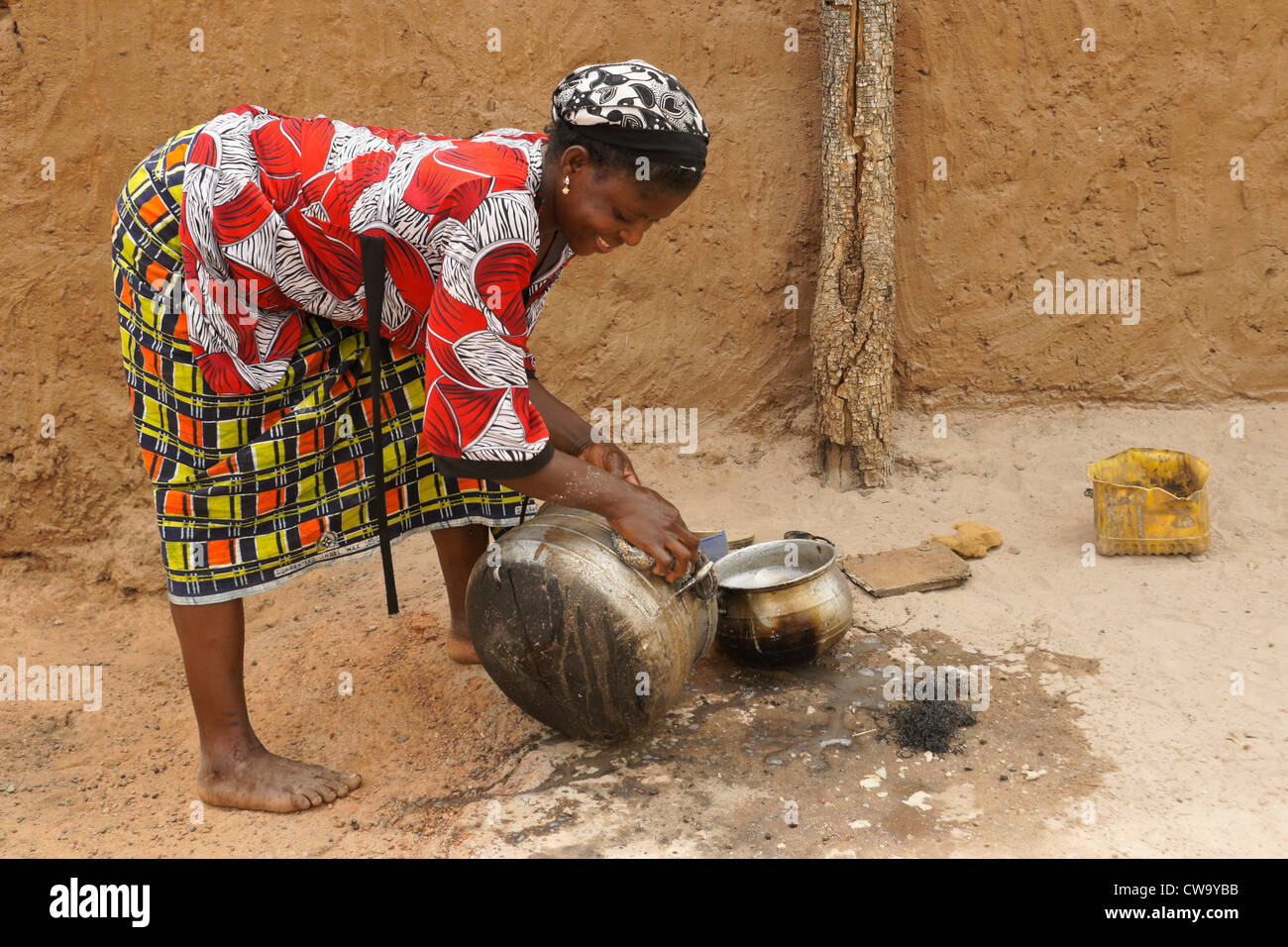 Woman scrubbing pot in Mognori Eco-Village, Ghana Stock Photo