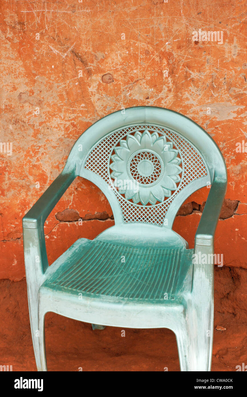 Plastic chair sitting against orange wall, Ghana Stock Photo Alamy