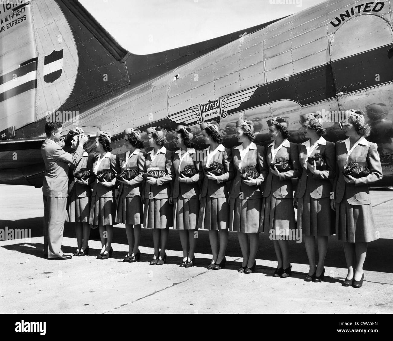 Don F. Magarrell gives new United Airlines stewardesses their wings. The national defense business caused a growth in air Stock Photo
