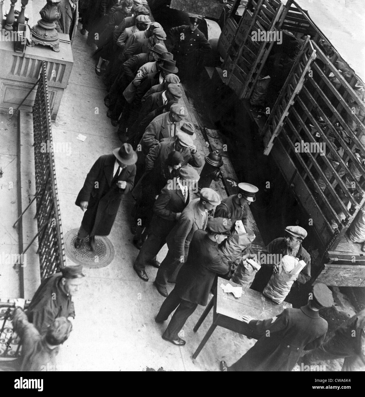 Food handouts in New York in 1930. Police stations were used as distribution centers. Photo shows food being distributed in Stock Photo