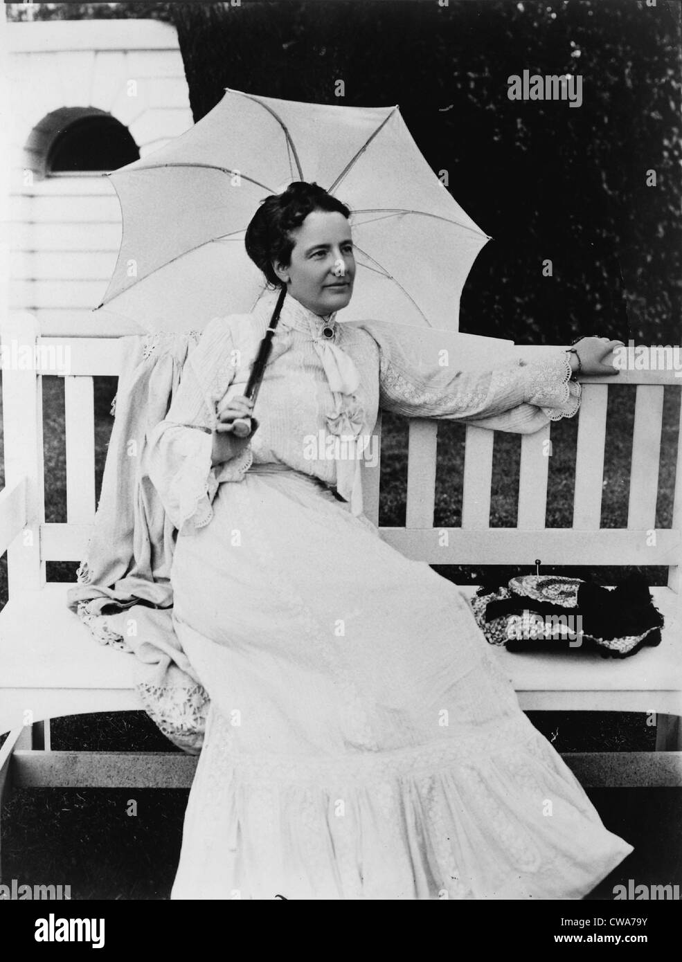 Portrait of First Lady, Edith Kermit Carow Roosevelt, seated outdoors on bench, holding umbrella. Ca. 1900-08. Stock Photo