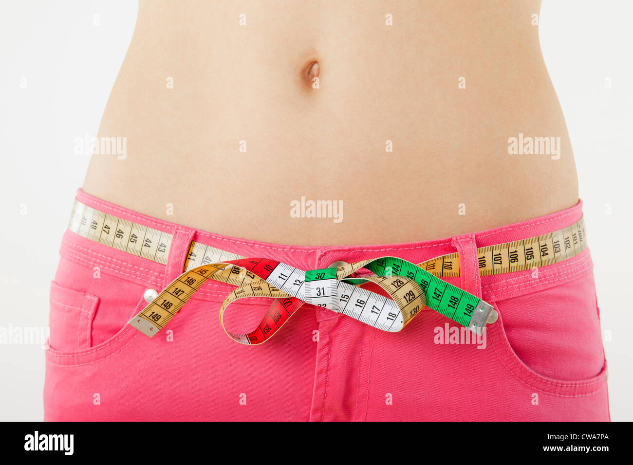 Young woman measuring waist with tape measure Stock Photo