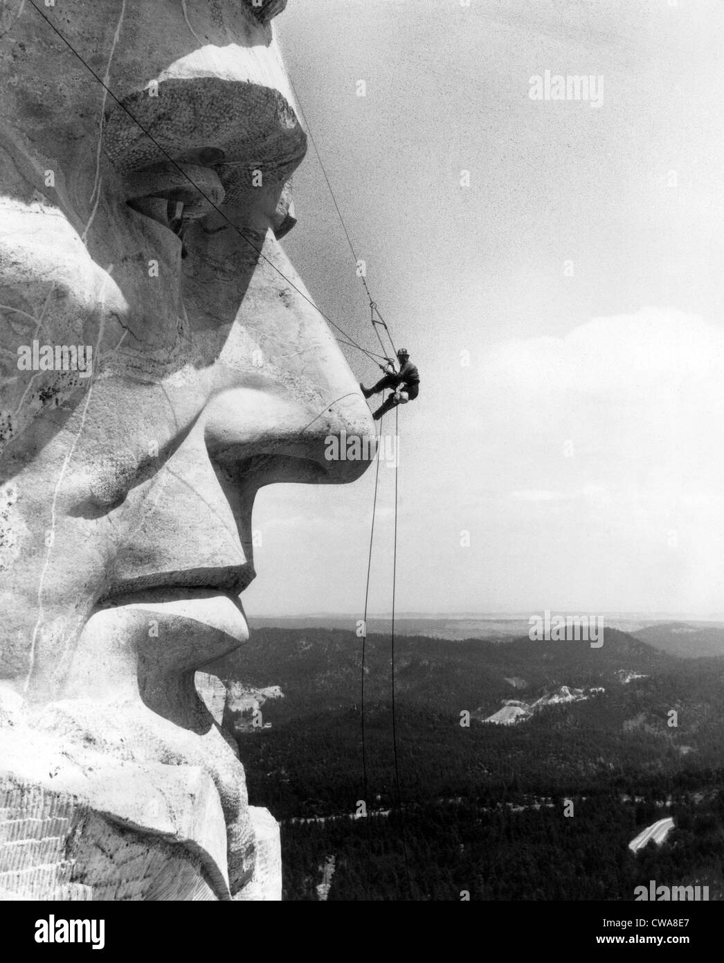 A maintenance worker on the nose of Mount Rushmore's Abraham Lincoln, South Dakota, c. 1960s.. Courtesy: CSU Archives / Everett Stock Photo